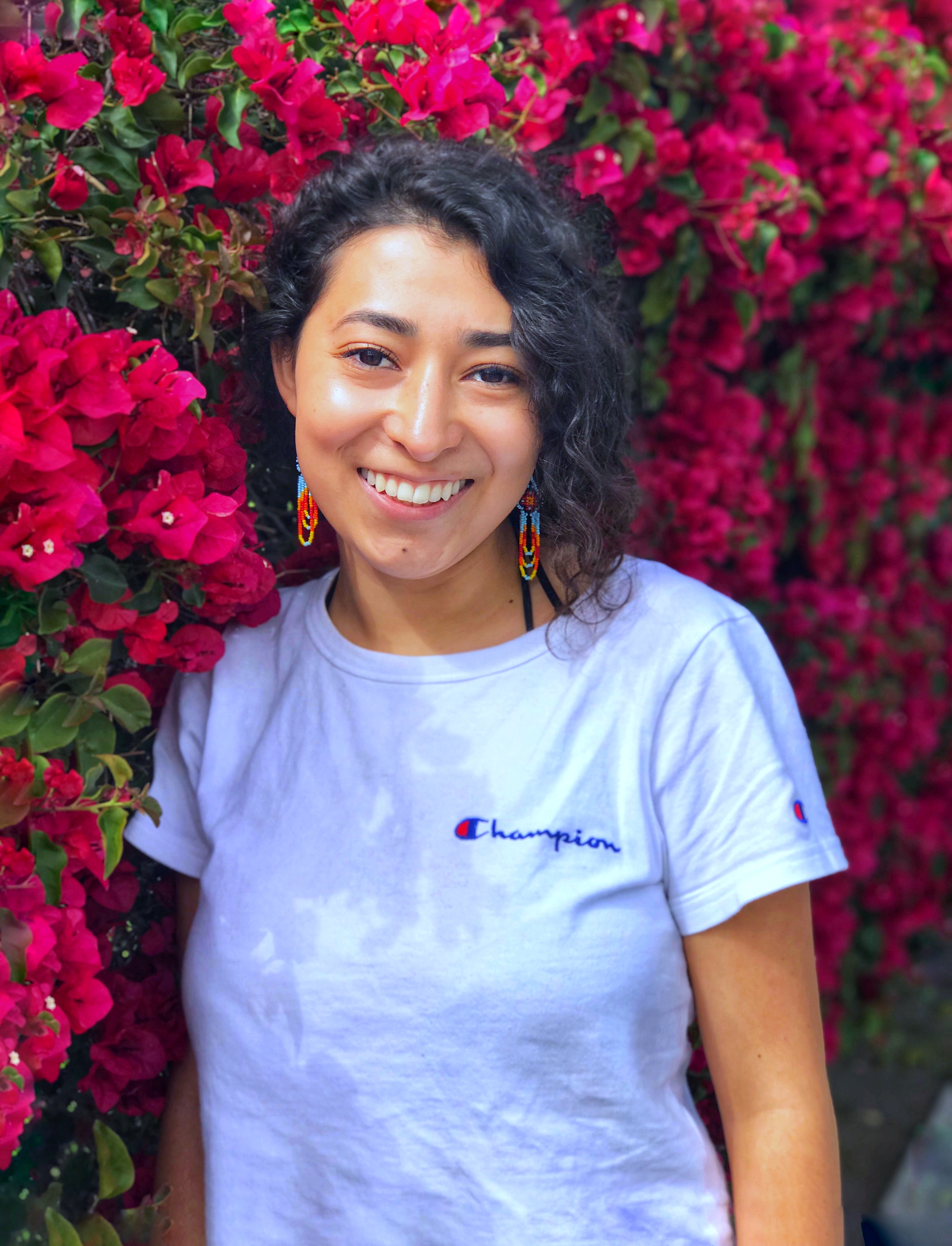 Krystal standing in front of a pink Bougainvillea bush